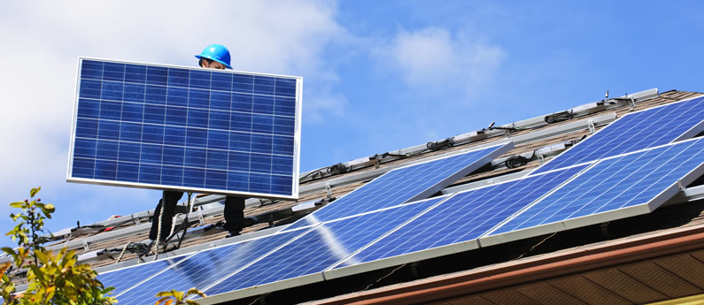 Een installateur plaatst zonnepanelen op een dak.