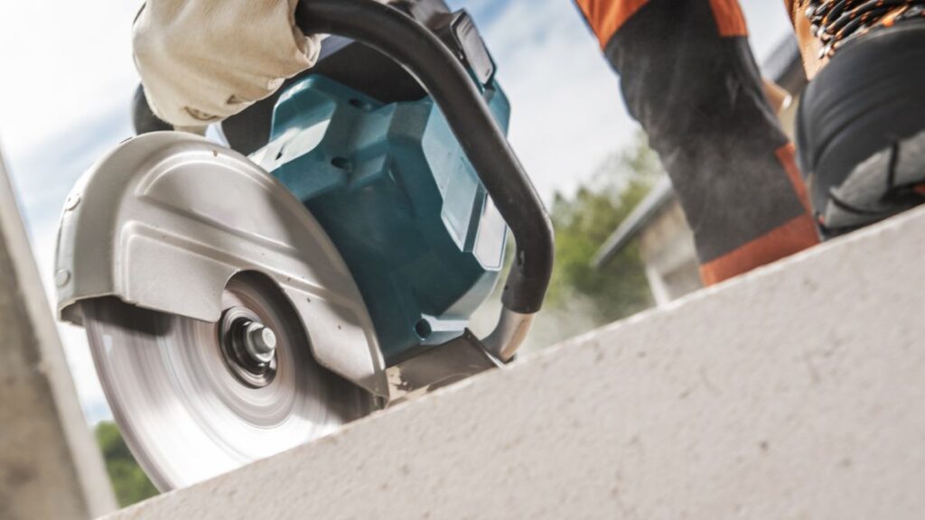 Een specialist gebruikt professionele apparatuur om in beton te zagen