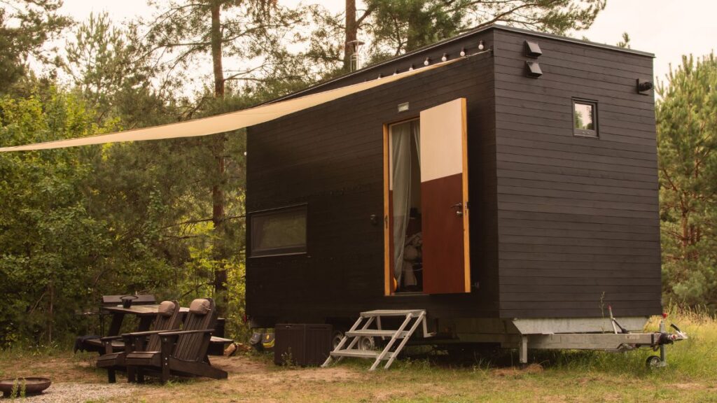 Een houten tiny home met zonnescherm