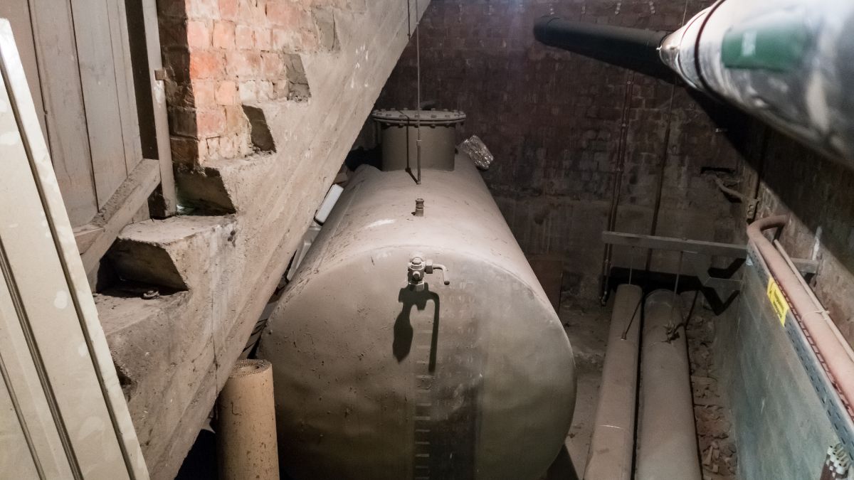Een oude mazouttank onder een keldertrap.