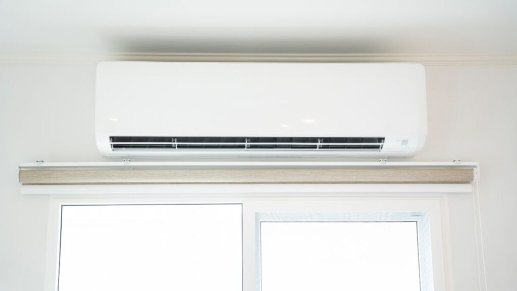 Een geïnstalleerde wandairco boven een raam in een moderne woning. Ontvang eenvoudig een offerte airco voor dit type installatie.
