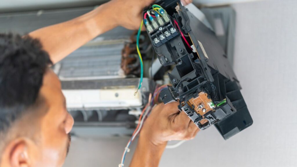 Specialist controleert bedrading en componenten bij airco herstellen.