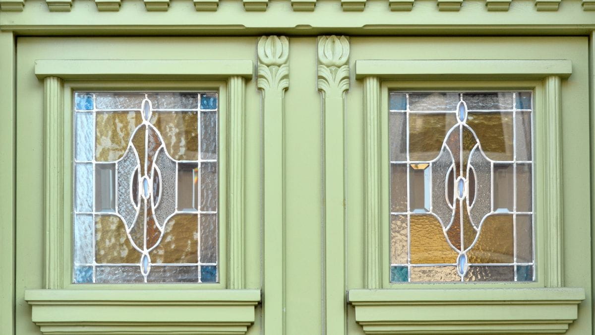 Glas-in-lood in groene deuren of ramen met blauwe en gele elementen
