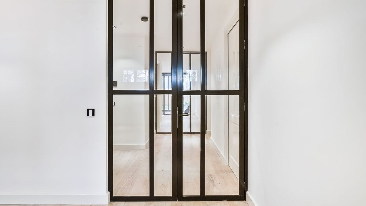 Moderne zwart stalen deur met glasverdelingen en zwart deurbeslag 