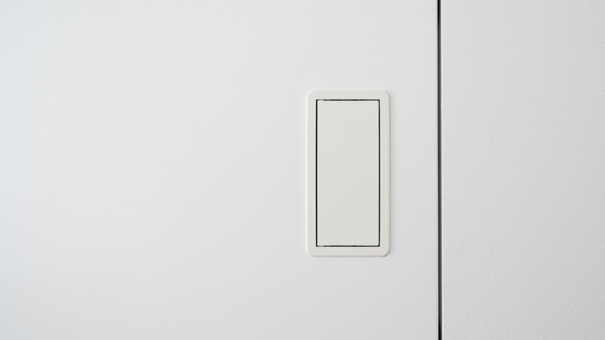 Detail van een witte blokdeur met schaduwvoeg en een witte, rechthoekige vingergreep. 