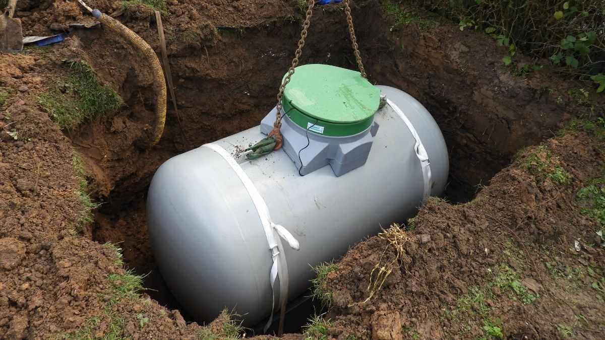 Ondergrondse gastank plaatsen: propaantank wordt met hijskettingen in een uitgegraven tankput in de tuin neergelaten